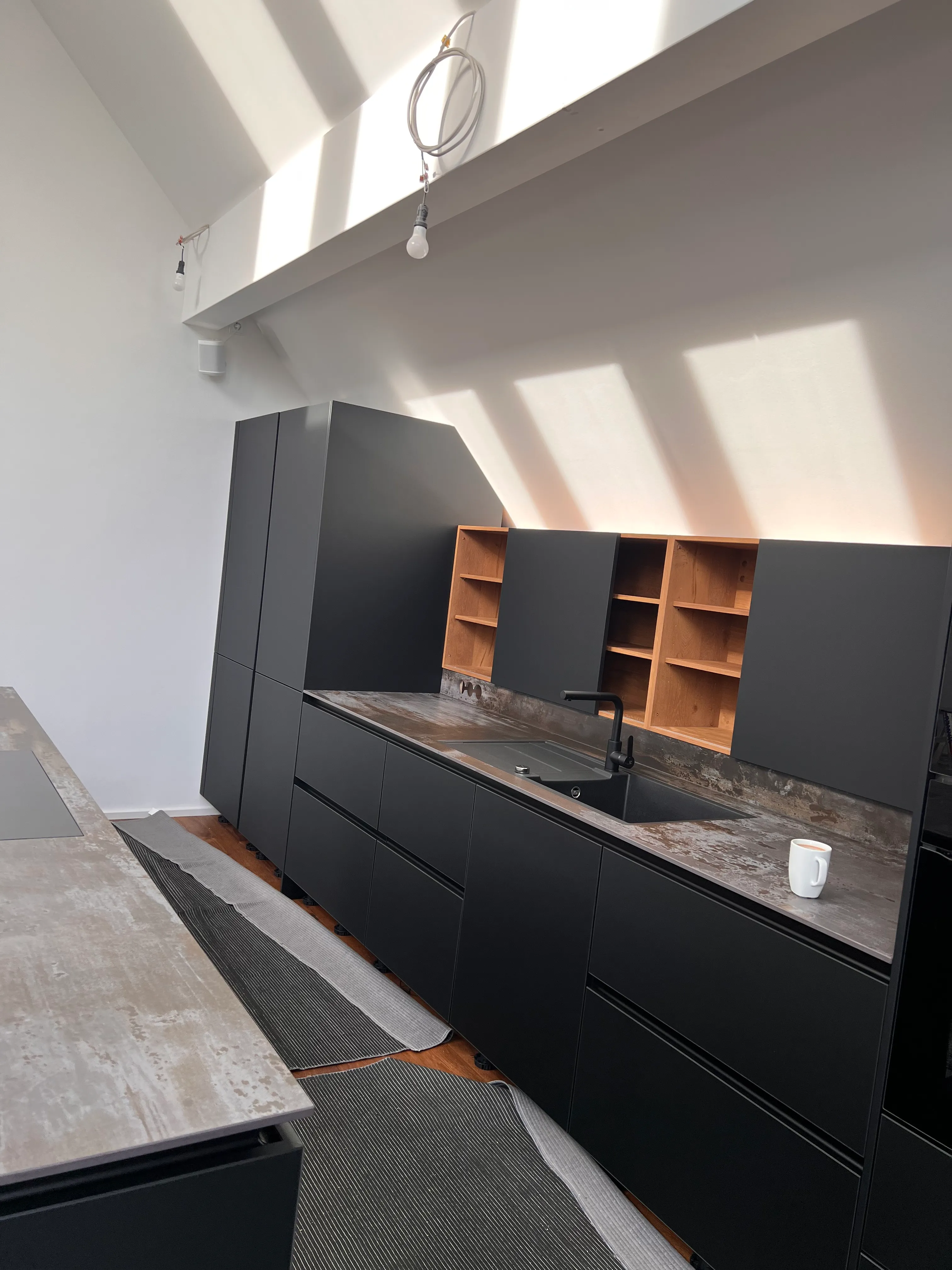Holzregale mit dunklen Armaturen – Detail der grauen Küche