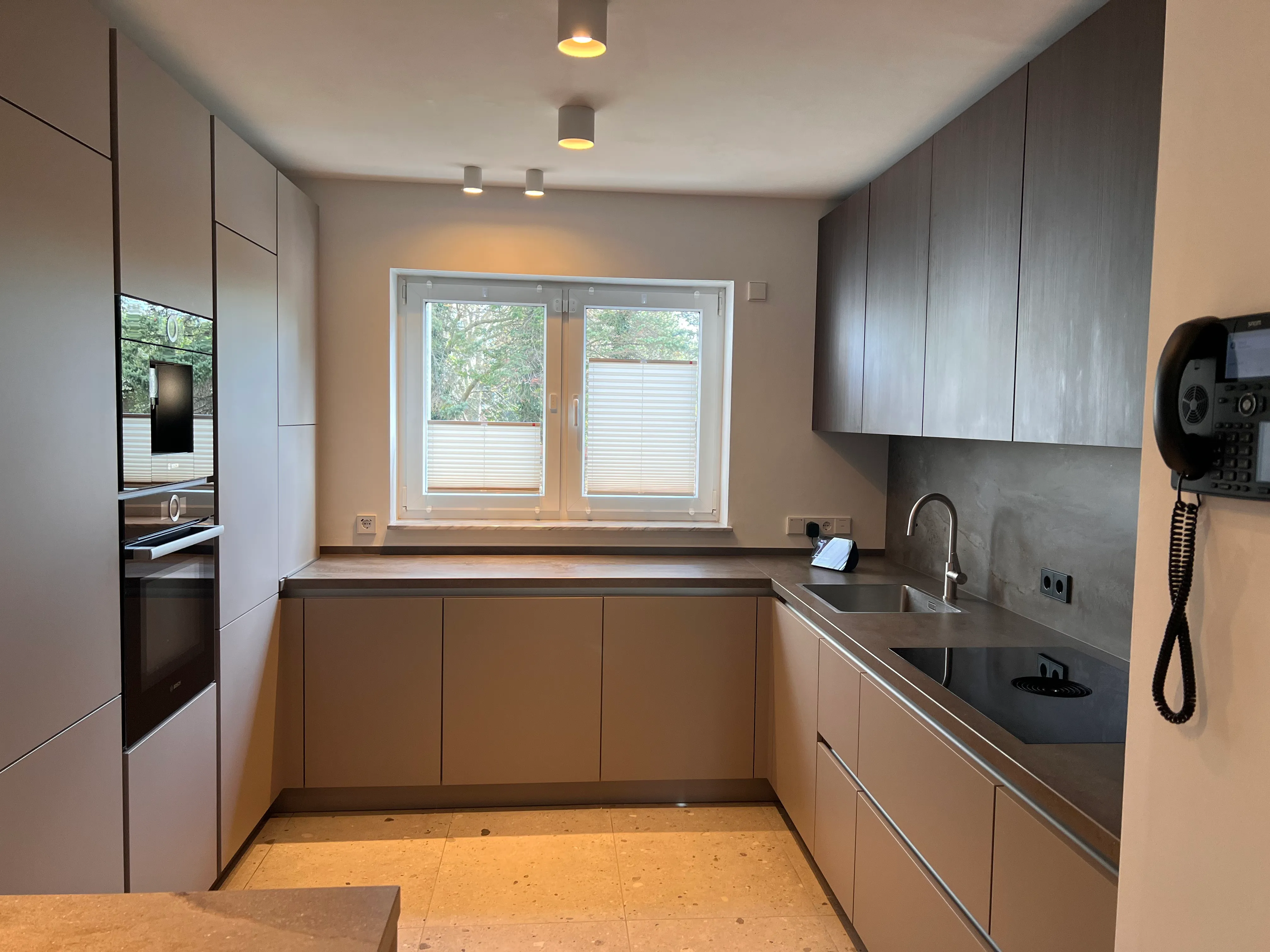 Dunkelgraue U-Küche mit brauner Arbeitsplatte und Tresen