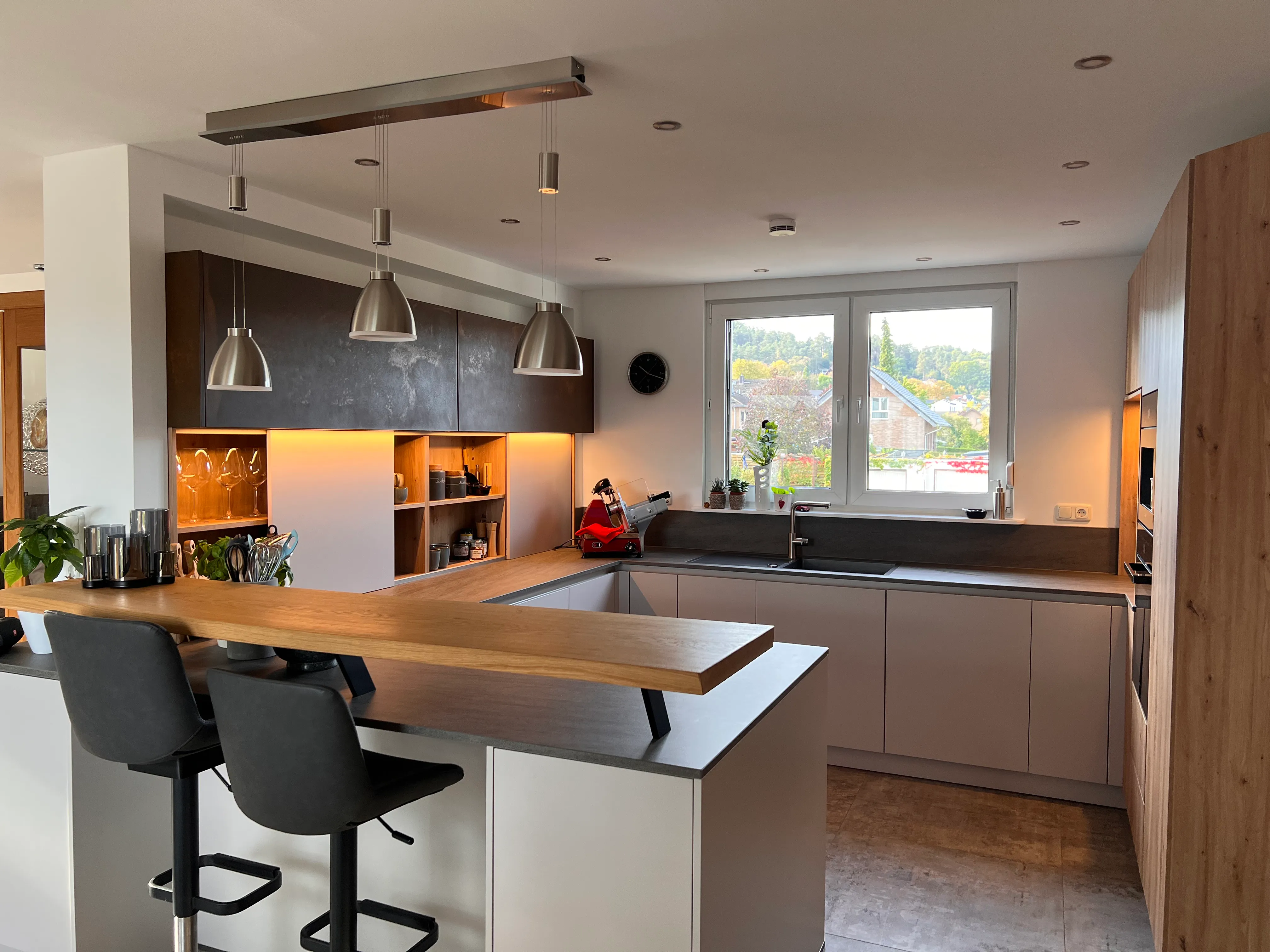 Weiße U-Küche mit grauer Arbeitsplatte und Massivholztresen