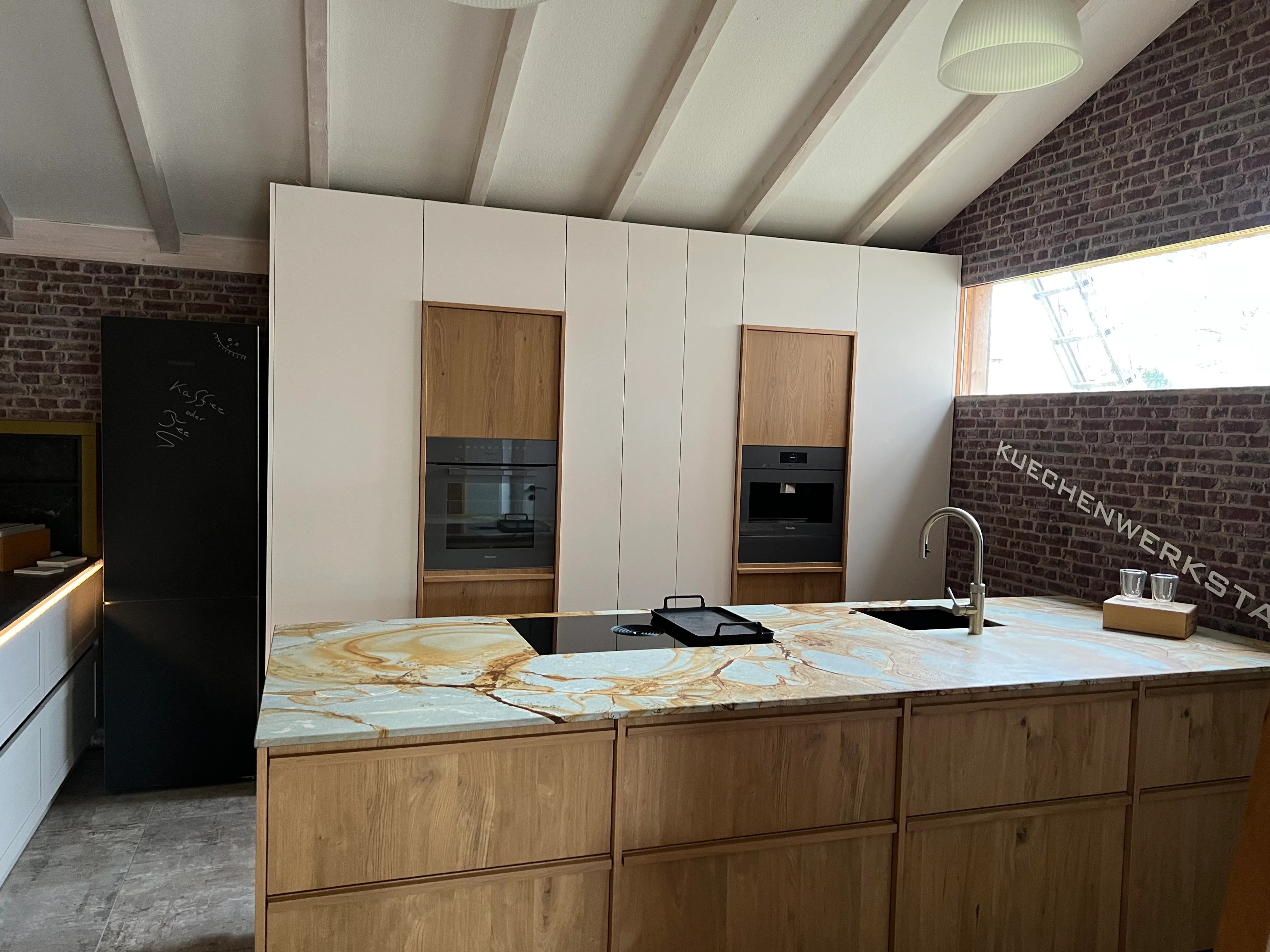 Moderne Musterküche mit Kochinsel aus Eichenholz und Marmor-Arbeitsplatte